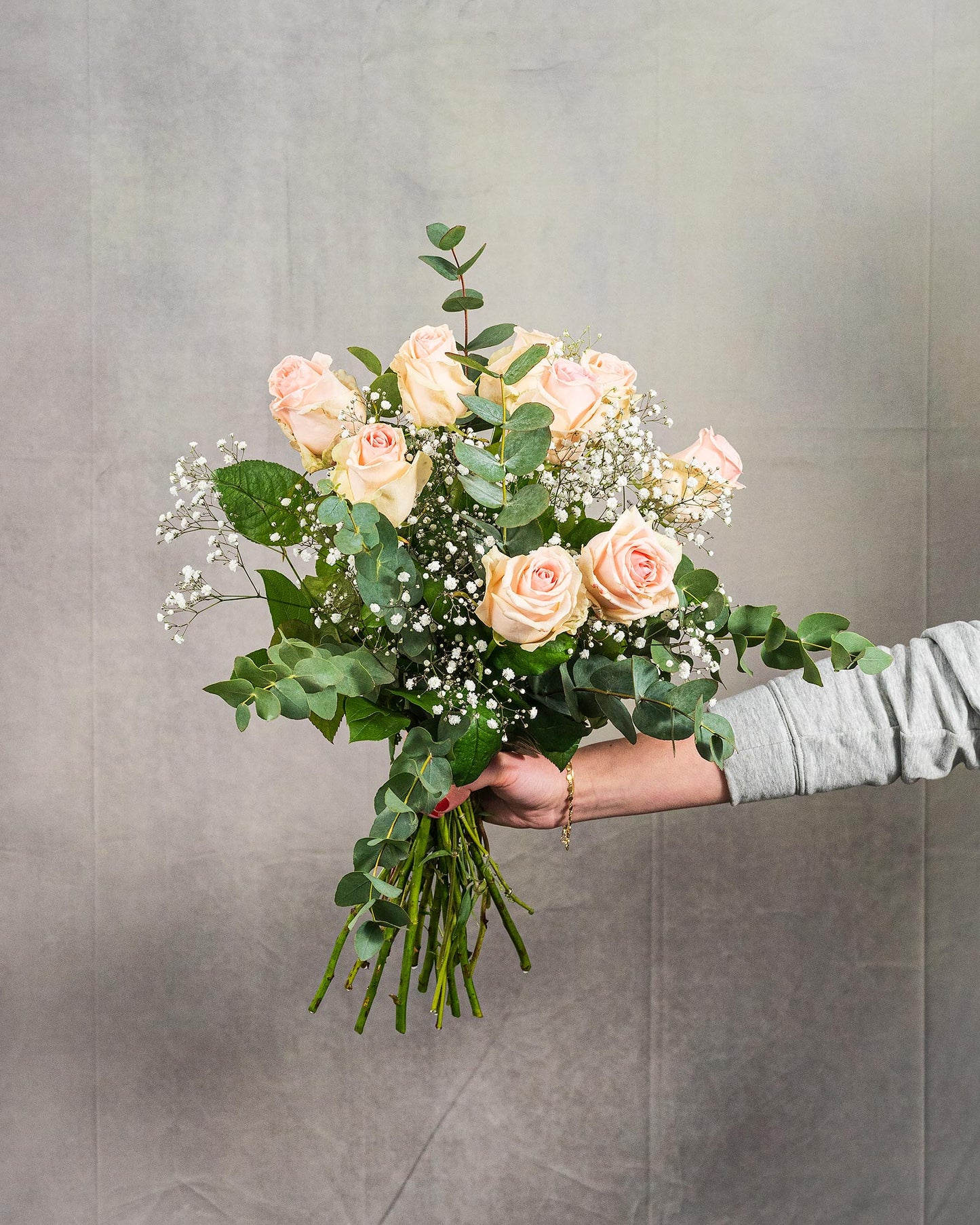 Mittelgroßer Strauß mit rosa Rosen, Schleierkraut und Eukalyptus, von Hand gehalten