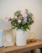 Blumenstrauß mit rosa Pfingstrosen in weißer Vase